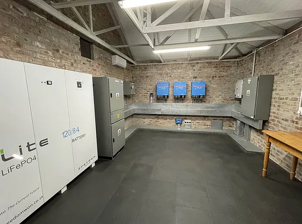 A battery room with large lithium battery cabinets and inverters