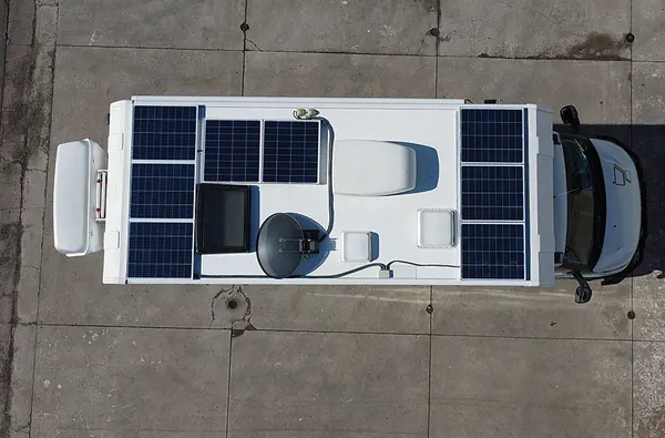 A caravan roof from above with solar panels around the vents