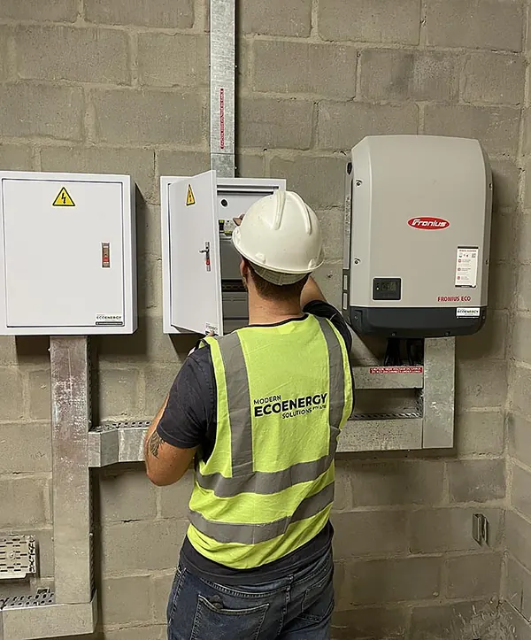 A Modern Eco Energy electrician in hi-vis working on a Fronius installation
