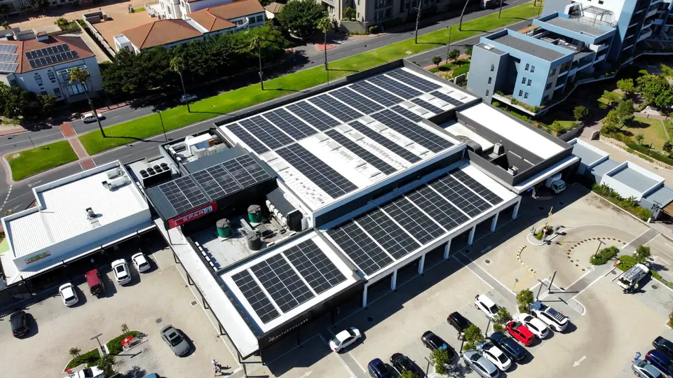 Aerial view of a retail centre with solar arrays on every roof plane