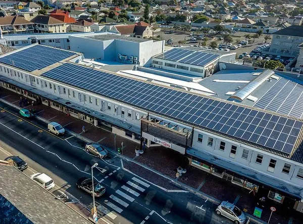 A main-road retail block with a long rooftop array