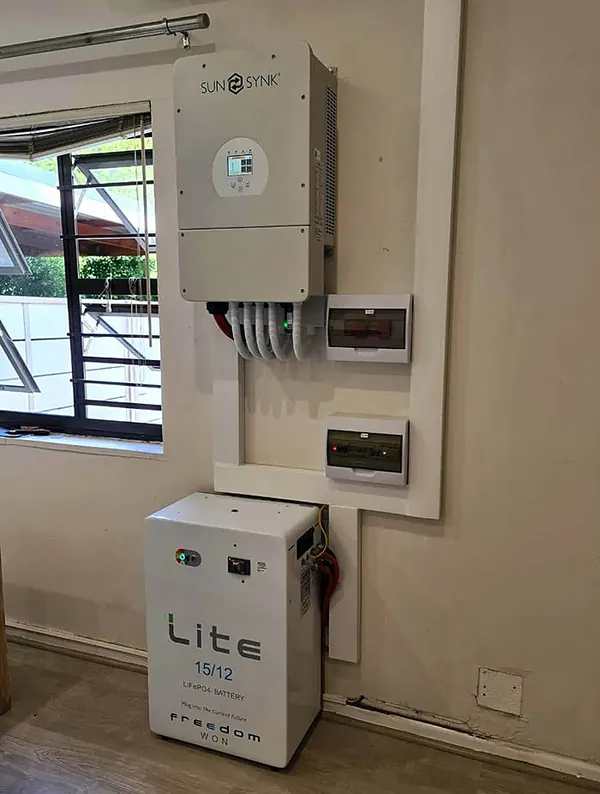 A hybrid inverter above a Freedom Won Lite battery in a home