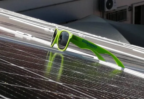 Green Modern Eco Energy sunglasses resting on a solar panel